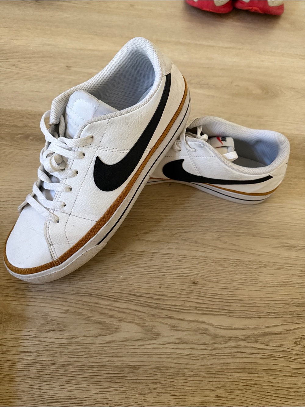 Nike White Low-Top Sneakers with Black Swoosh and Brown Stripe